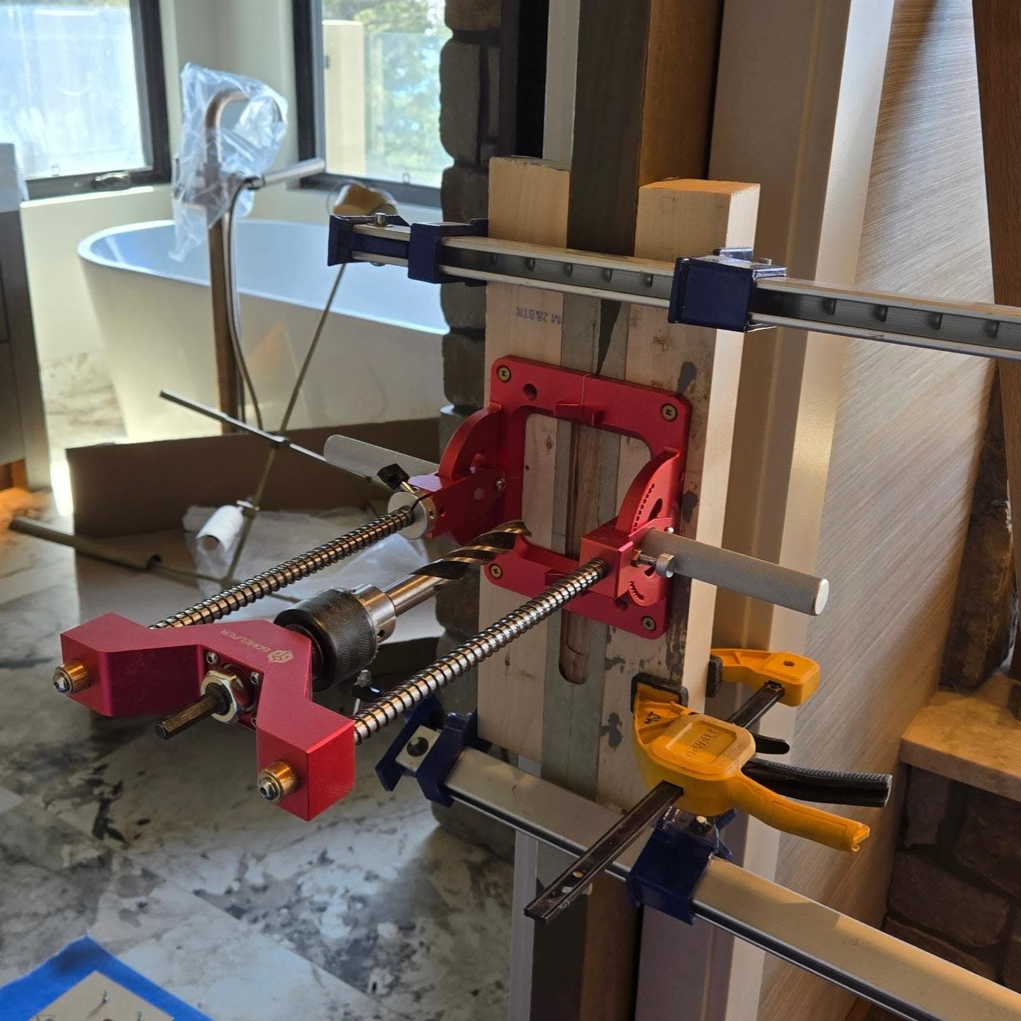 Precision doweling jig clamped to a door stile on a renovation job site