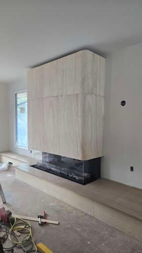 Modern floor-to-ceiling floating fireplace surround mid-installation