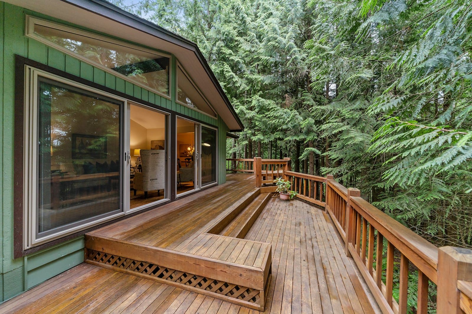 Wooden deck with railing surrounded by forest